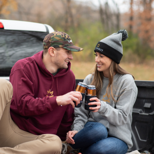 Man and woman sharing stories in Pickup Truck toasting at the cabin in the fall